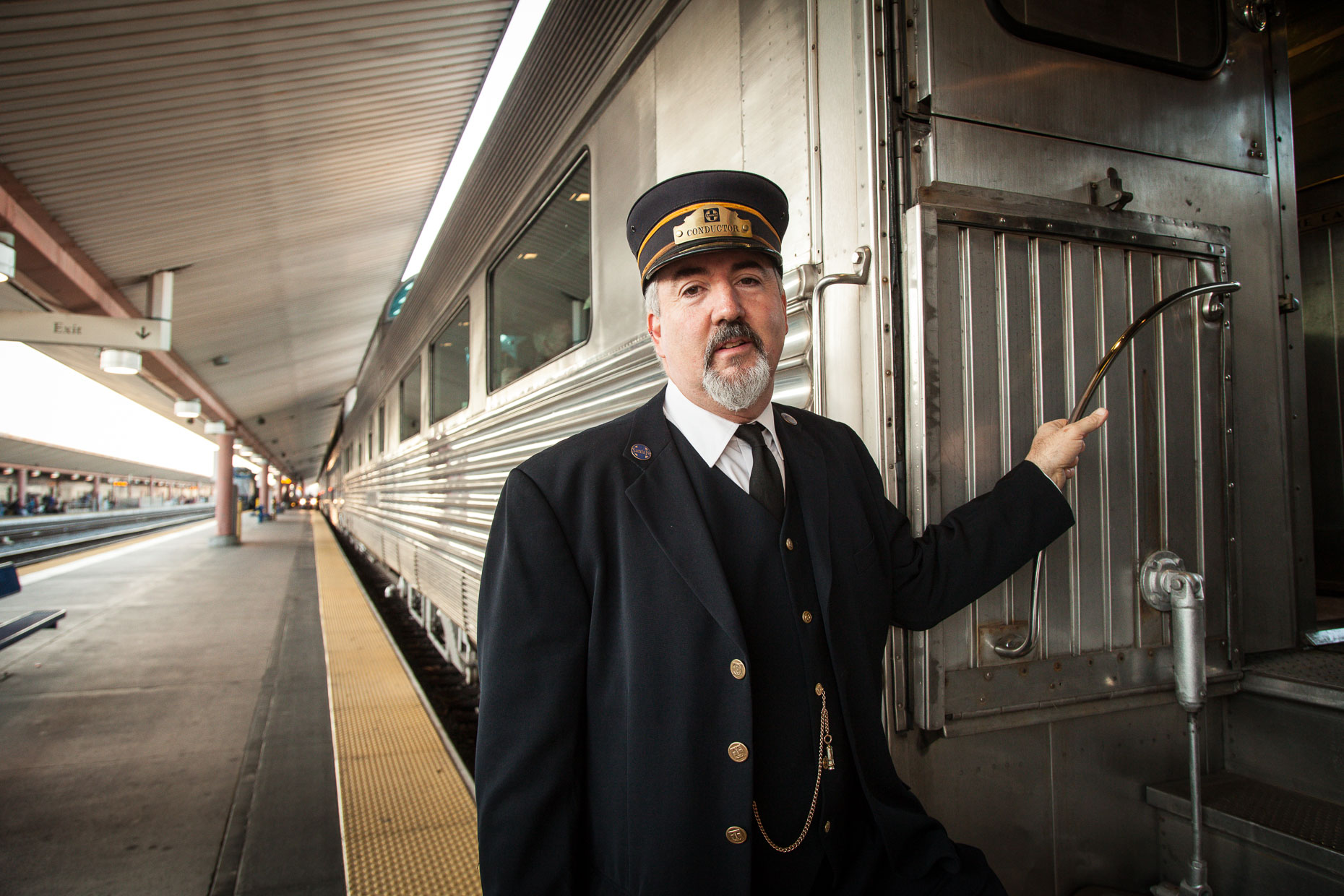 Portrait of train conductor standing near train doorway at Union Station in Los Angeles, California.