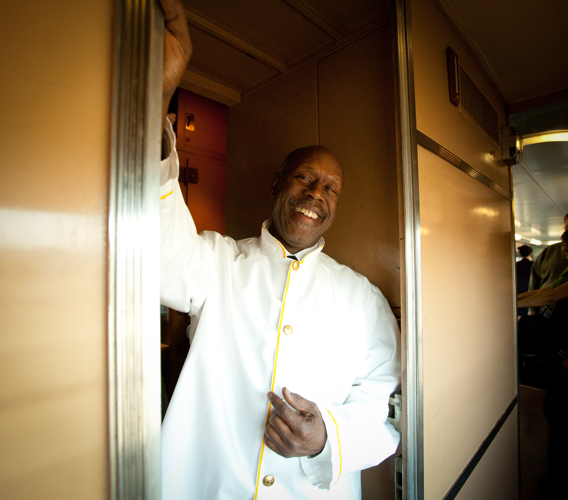 Environmental portrait of African American chef on train standing in kitchen doorway