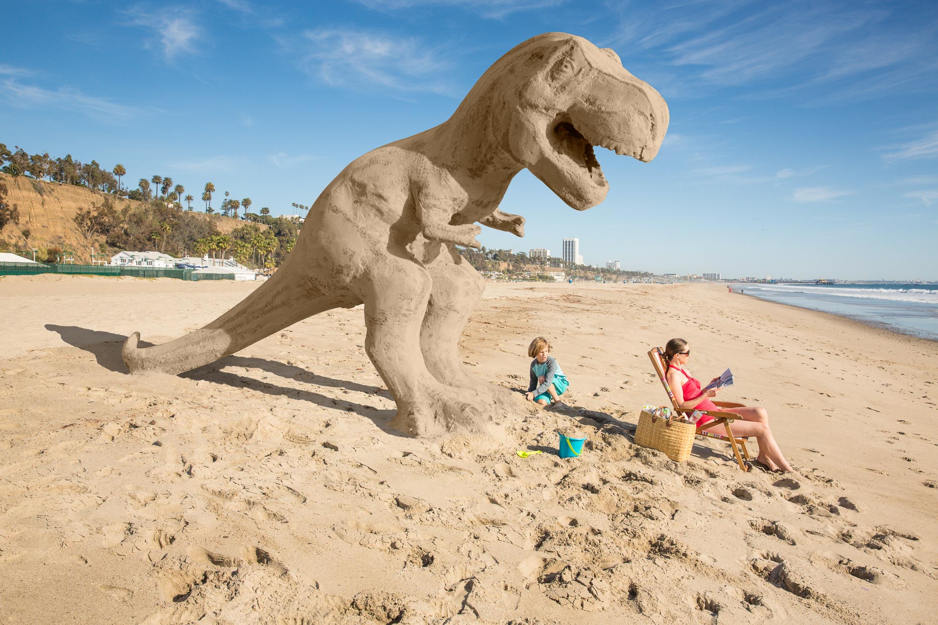 Boy makes sand castle in shape of giant T-Rex while mom doesn