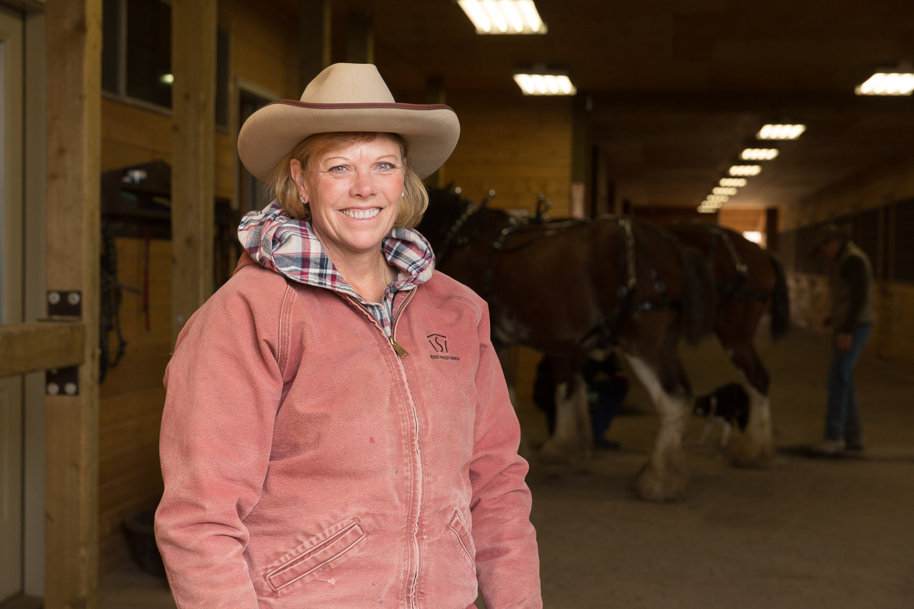 Portrait of Sandy Campbell standing in horse stables at Silvies Valley Ranch in Seneca, Oregon by David Zaitz