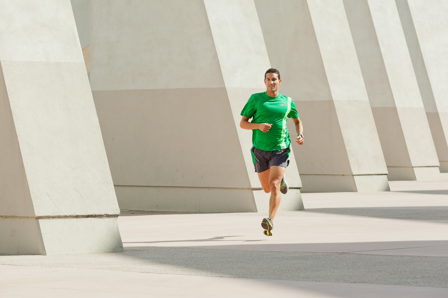 Man running with concrete diagonal structure in background. San Diego, California. Fitness by David Zaitz Photography. 