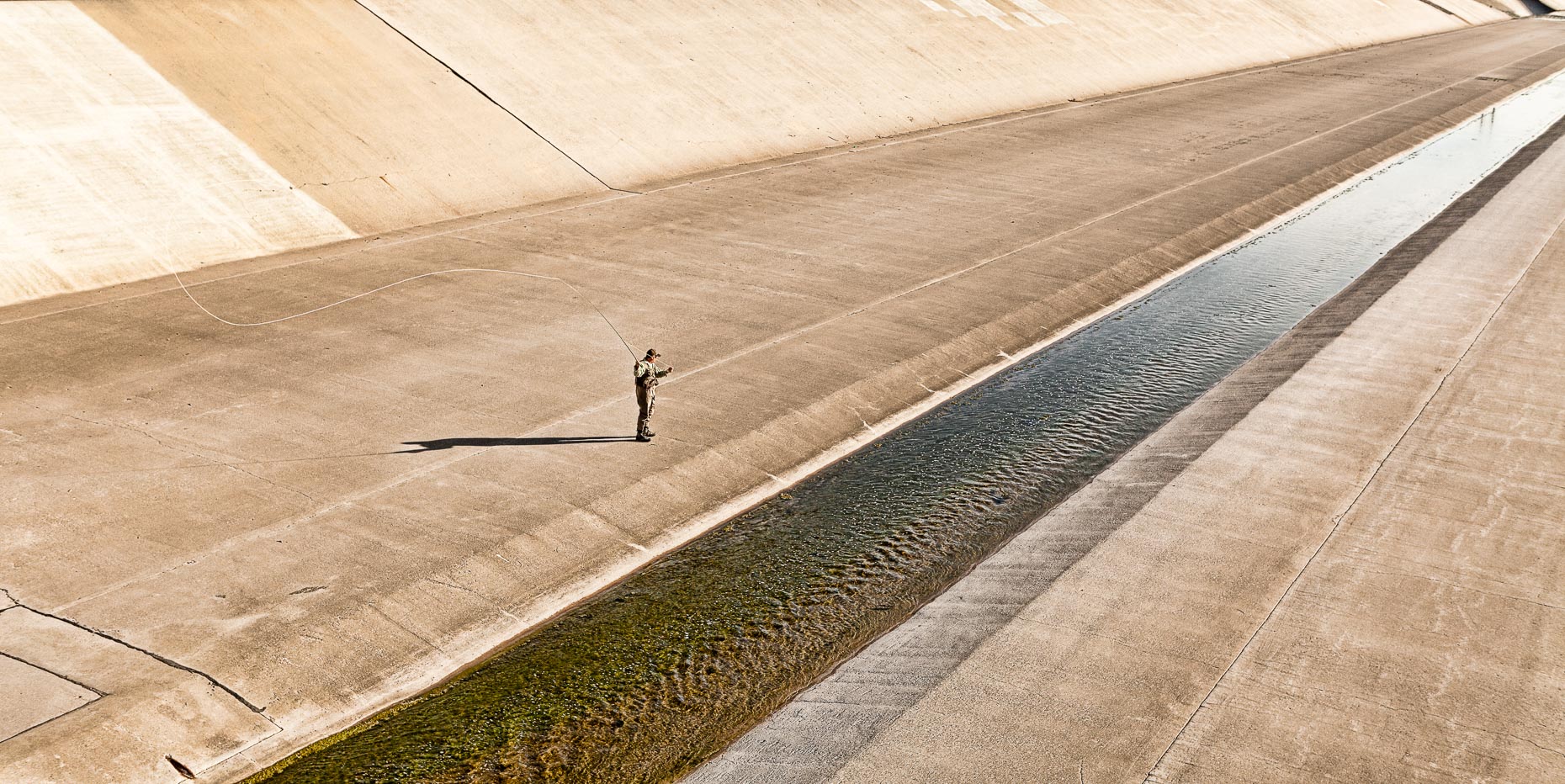 Man fly fishing in concert storm channel. David Zaitz