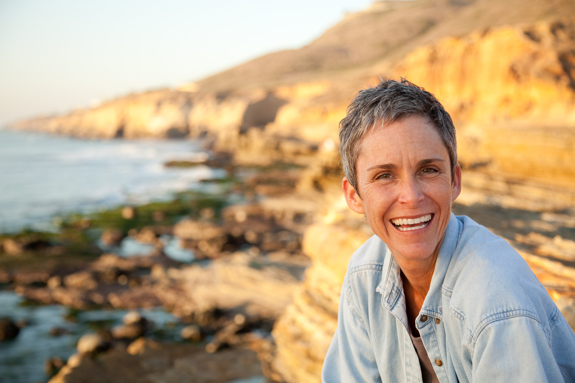 Environmental portrait of woman on rocky ocean shoreline in San Diego, California by David Zaitz