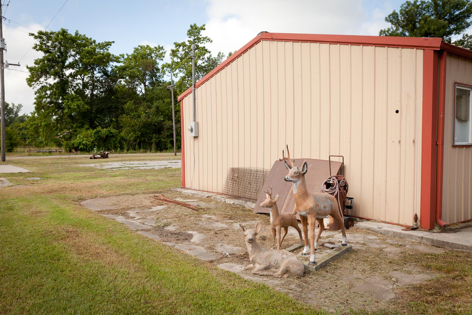 Concrete deer sculptures next to metal building by David Zaitz