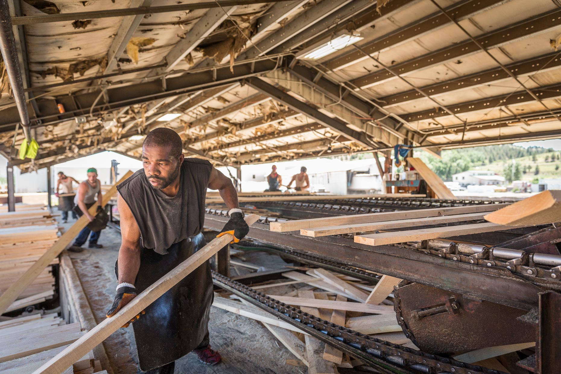 African American male sorting cut lumber, Malheur Lumber Company mill in John Day, Oregon by David Zaitz.