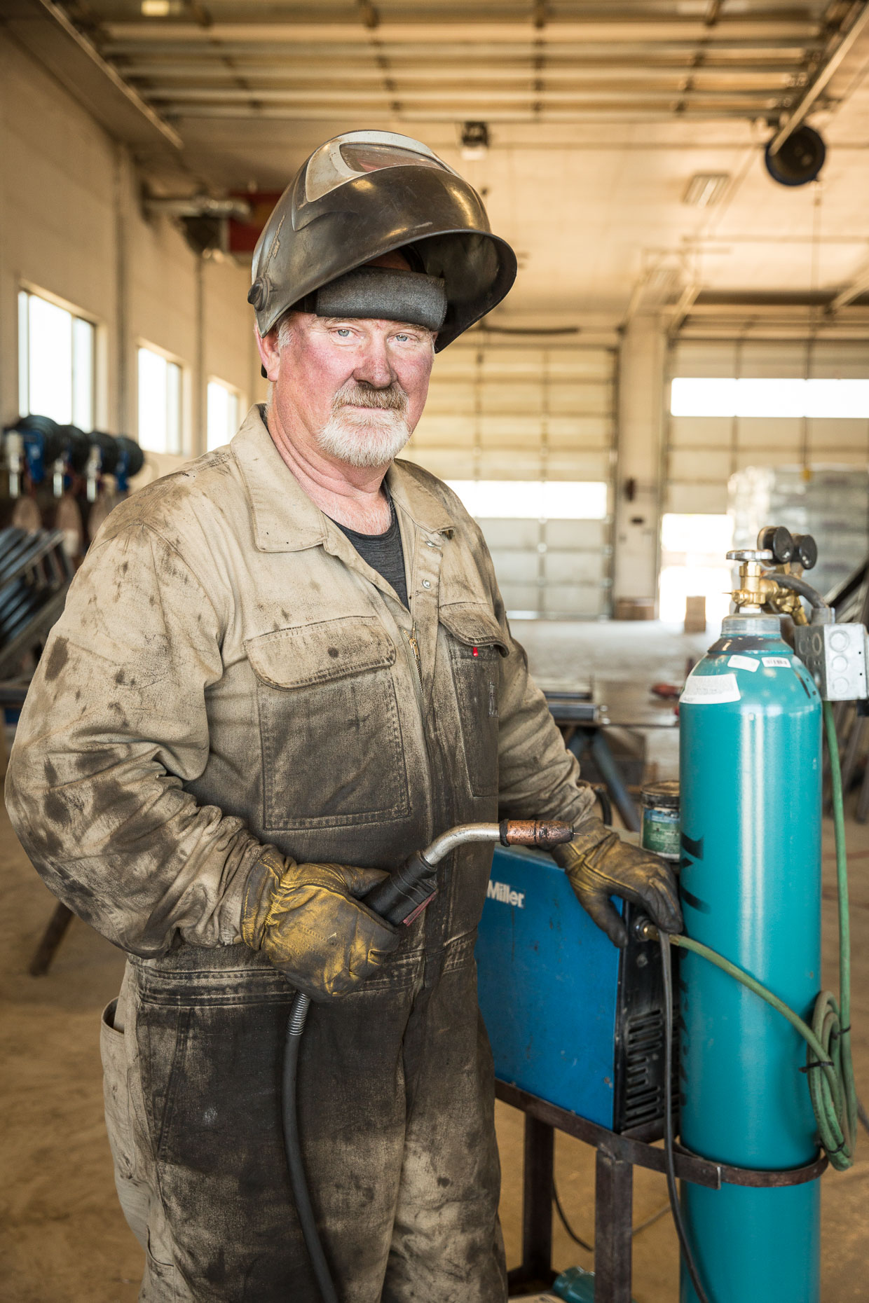 Environmental portrait of welder in workshop.
